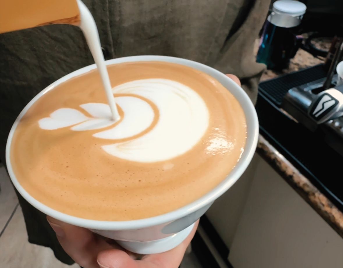 Barista desenhando latte art com leite vaporizado
